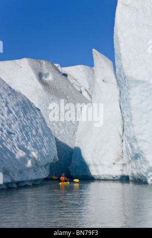 A kayaker paddles and explores the seracs of Mendenhall Glacier on a crisp Fall morning, Alaska Stock Photo