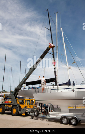 yacht mast being removed using yard crane in cowes yacht haven Stock Photo