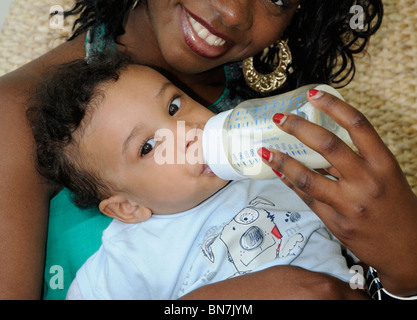 Baby boy being bottle fed by his mother Stock Photo