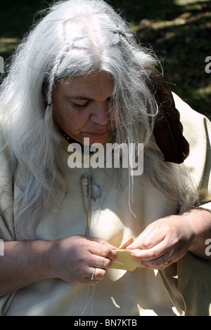 An older Native American Indian women sewing leather clothes Stock Photo