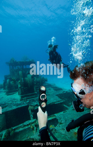 Diver checks remaining air supply and depth via his scuba console while diving in Grand Cayman Stock Photo