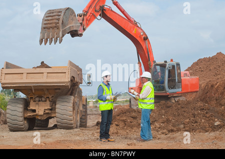 Hispanic construction workers talking on construction site Stock Photo