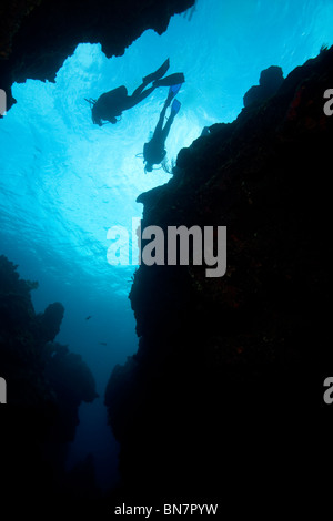 Scuba divers descend in order to peer through cavern in the Caribbean Sea