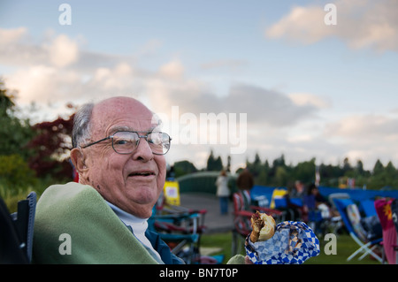 An elderly man enjoys a barbecued sandwich at the annual Artesian Family Festival in Tumwater, WA on the 4th of July. Stock Photo