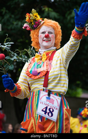 A colorful clown waves to the crowd of spectators during the annual 4th of July parade in downtown Tumwater, Washington. Stock Photo