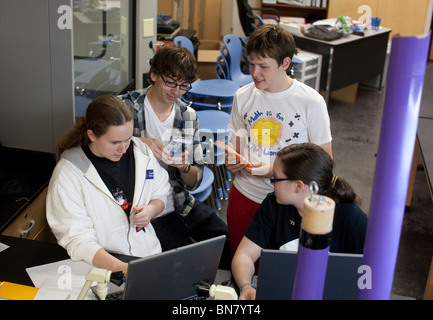 High school students collaborate in class using laptop computers to do research. Stock Photo