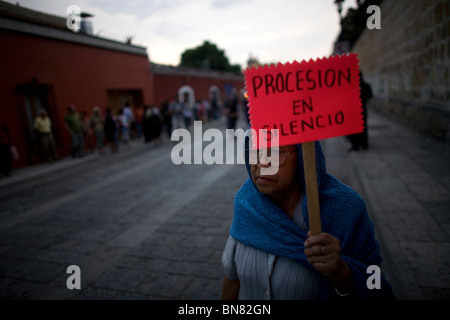 An elderly woman displays a sign that reads 'Procession in silence' during holy week celebrations in Oaxaca, Mexico. Stock Photo