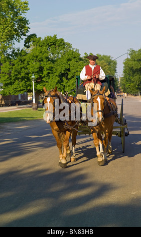 Tourists can enjoy a horse-drawn carriage ride through the streets of Colonial Williamsburg, an18th-century living-history attraction in Virginia, USA. Stock Photo