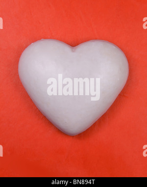 White heart (ginger cake) on red background Stock Photo