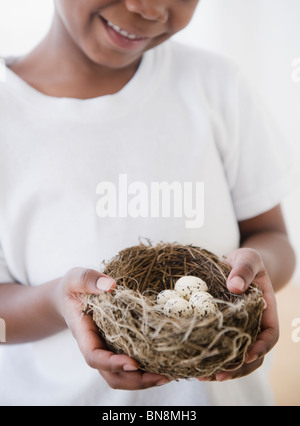 Black boy holding nest with bird's eggs Stock Photo