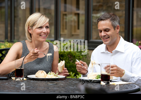 Business couple eating lunch outdoors at hotel Stock Photo