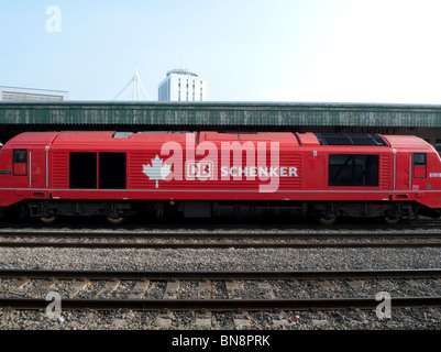 A red German Schenker railway carriage cargo train on the rail track at Cardiff Station, Wales UK   KATHY DEWITT Stock Photo