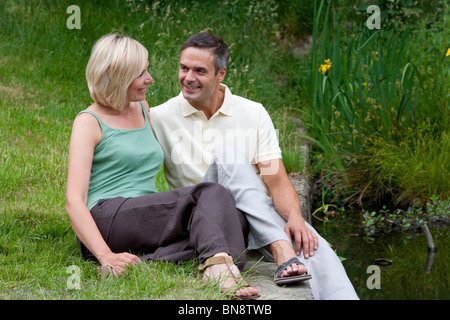 Couple 30s relaxing by lake Stock Photo