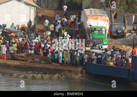 Africa, Gambia. Capital city of Banjul. Port area of Banjul. Crowds of passengers getting on ferry boat docked in Banjul. Stock Photo
