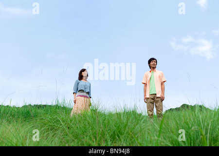 Mid adult couple standing in field looking away Stock Photo