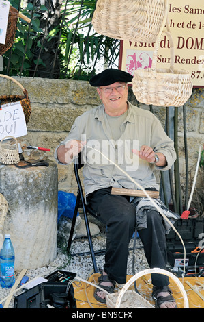 A basket weaver at an outdoor market, Southern France Stock Photo