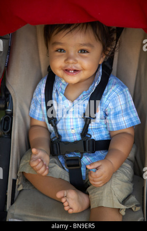 Mixed race boy sitting in stroller Stock Photo