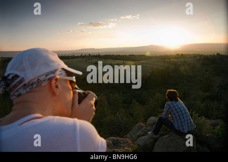 Friends resting on rocks in remote area Stock Photo