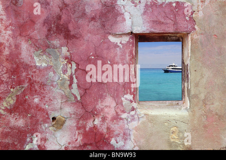 grunge pink red wall wood window tropical turquoise sea boat view Stock Photo