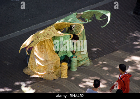 TWO FAIRY HUMAN STATUES FANCY DRESS STREET ARTISTS HAVING A BREAK AND COUNTING THEIR TAKINGS ON LAS RAMBLAS BARCELONA Stock Photo