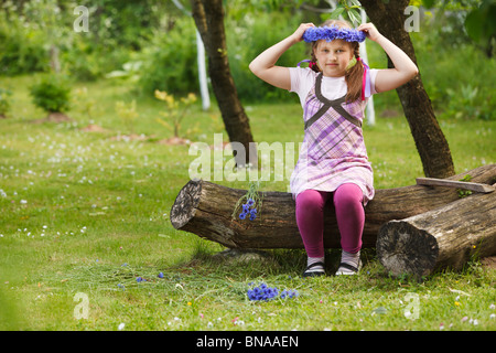 Little girl with a chaplet made from blue flowers Stock Photo