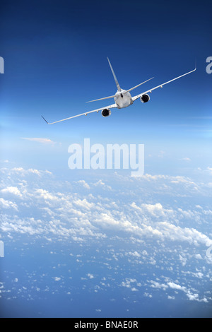 Jet airliner in flight with clouds in the distance Stock Photo