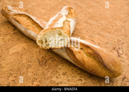 Crossed traditional French sticks on a cork background (France). Baguettes traditionnelles croisées sur fond de liège (France). Stock Photo