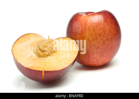 fresh vibrant Nectarine and slice with stone from low perspective isolated against white background. Stock Photo