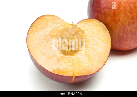 fresh vibrant Nectarine half with stone from low perspective isolated against white background. Stock Photo