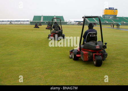 Riding Greens mowers machinery; Grass cutters and Green keepers mowing the Old Course;  Team maintenance at the 139th British Open Golf 2010, July 15-18, St Andrews, Scotland, UK. The  function of mowing is to prepare the golf course for play although mowing patterns are often used to highlight  features of a golf course. The mowing pattern can have a big impact on the appearance of the golf course and the health of the turf while affecting your labor and fuel consumption line items. The most common fairway mowing methods are striping, contour mowing, the classic cut, and pushing and pulling. Stock Photo