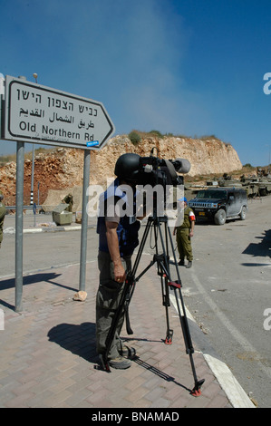 TV news crew wearing protective flak jacket filming Israeli troops mass at the northern Israel Lebanon border Stock Photo