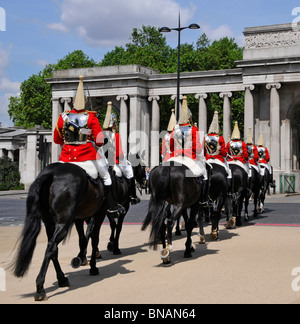 Hyde Park Corner screen back view Life Guards Household Cavalry Mounted Regiment soldiers red with cuirass after changing guard duty London England UK Stock Photo