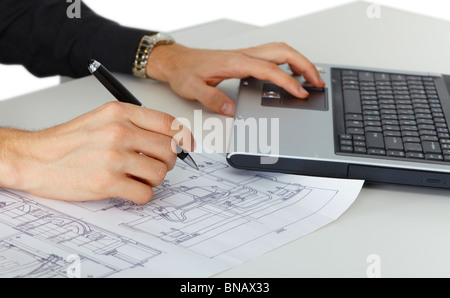 A man working on an engineering project with drawings and computer Stock Photo