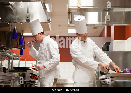 Chefs preparing food in commercial kitchen Stock Photo