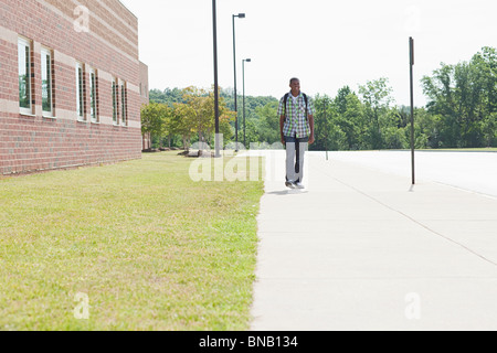Male high school student walking by school Stock Photo