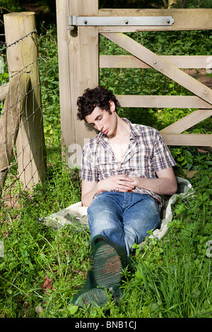 Young man asleep in countryside Stock Photo