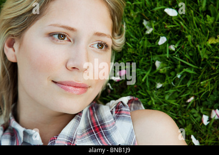 Face of young woman lying on grass Stock Photo