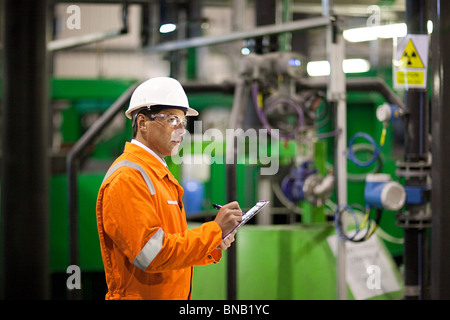 Engineer inspecting machinery in factory Stock Photo