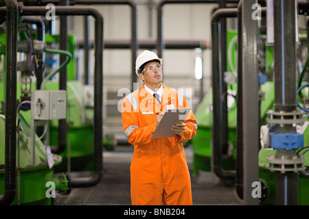 Engineer inspecting machinery in factory Stock Photo
