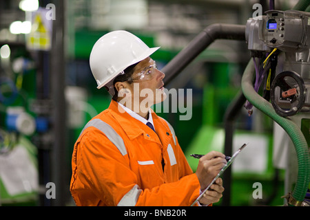 Engineer inspecting machinery in factory Stock Photo