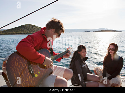 Friends with guitar on yacht Stock Photo