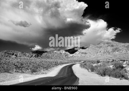 Road and thunderstorm clouds with Rock formations in Red Rock Canyon National Conservation Area, Nevada Stock Photo