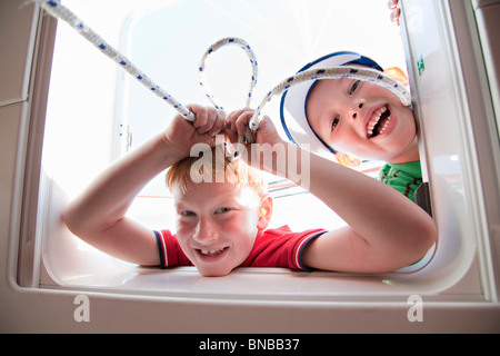 Two boys playing with hatch on yacht Stock Photo