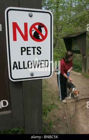 park No pets allowed sign woman walking dog ohio Stock Photo