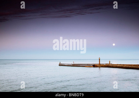 Tall ship sailing through harbour entrance at Whitby North Yorkshire, UK Stock Photo