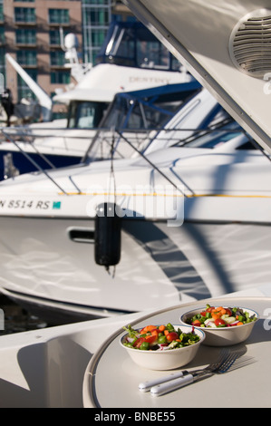 Salads are served on an outdoor table inside a boat moored in the Bell Harbor Marina in Seattle, Washington. Stock Photo