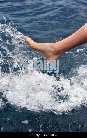 Foot of young man in water – splash Stock Photo