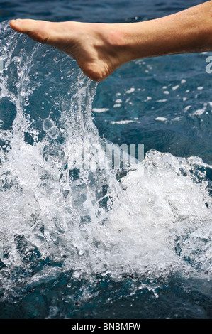 Foot of young man in water – splash Stock Photo