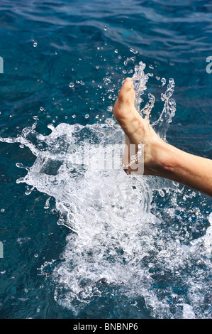 Foot of young man in water – splash Stock Photo