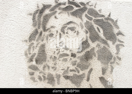 stenciled image of Jesus Christ, wearing a crown of thorns, on a wall. Stock Photo